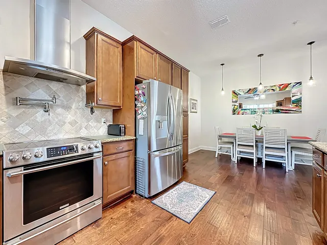a kitchen with stainless steel appliances a stove a sink and a refrigerator
