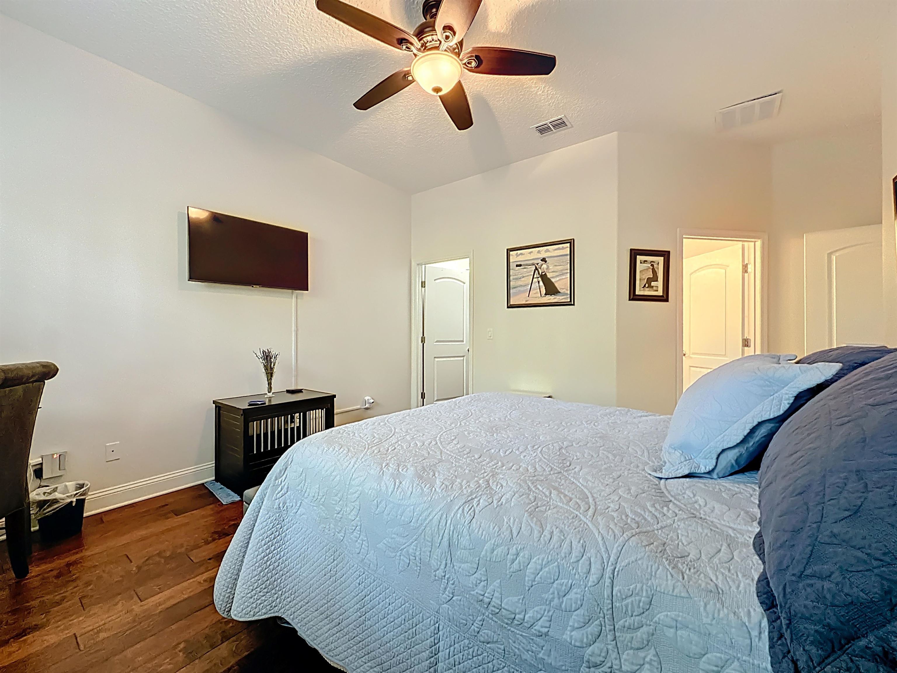 130 Grand Ravine Drive St. Augustine, FL 32086 - Photo 19 of 42 Bedroom with dark wood finished floors, a ceiling fan, and a textured ceiling