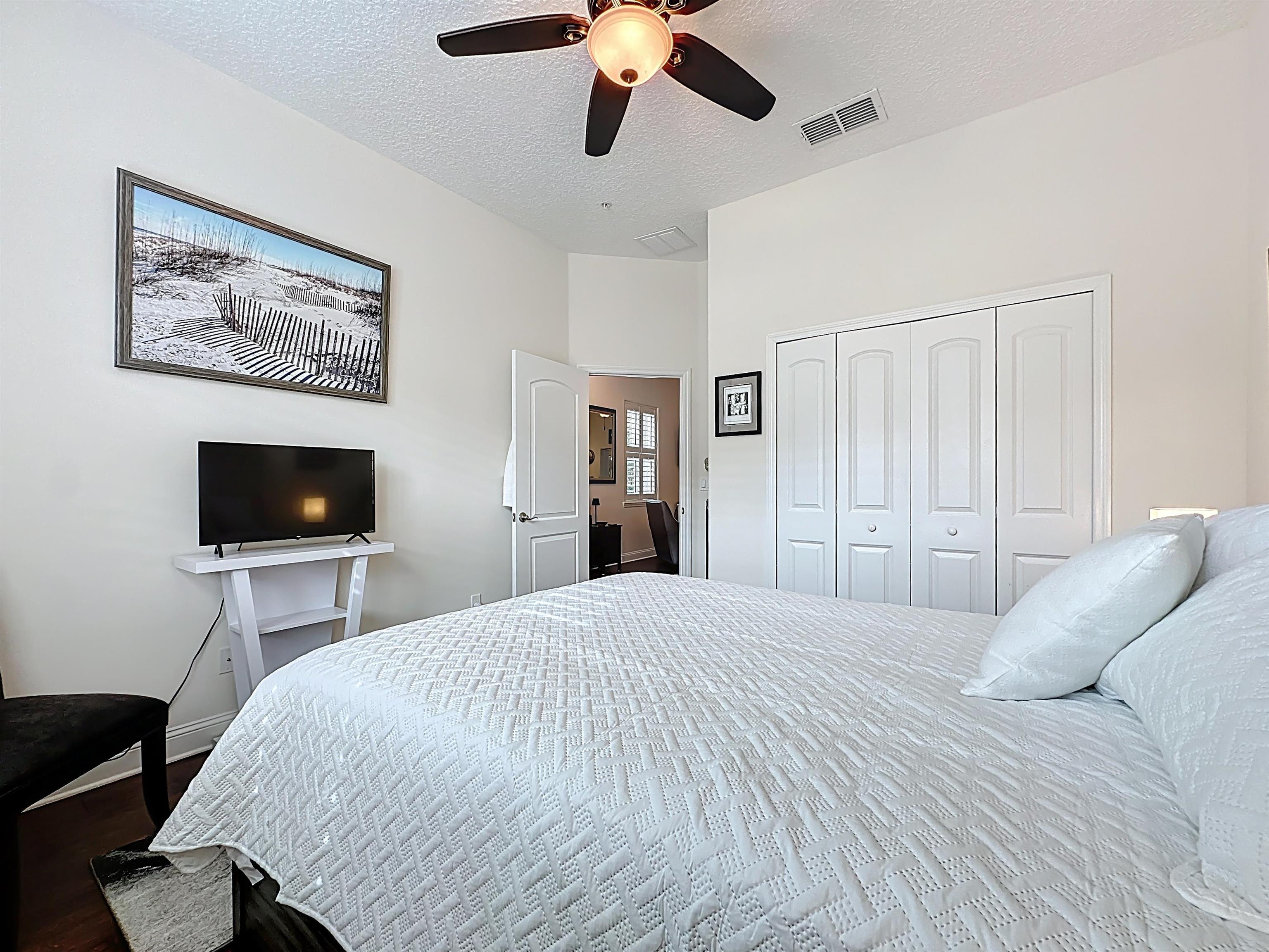 130 Grand Ravine Drive St. Augustine, FL 32086 - Photo 28 of 42 Bedroom with a textured ceiling, a ceiling fan, a closet, and wood finished floors
