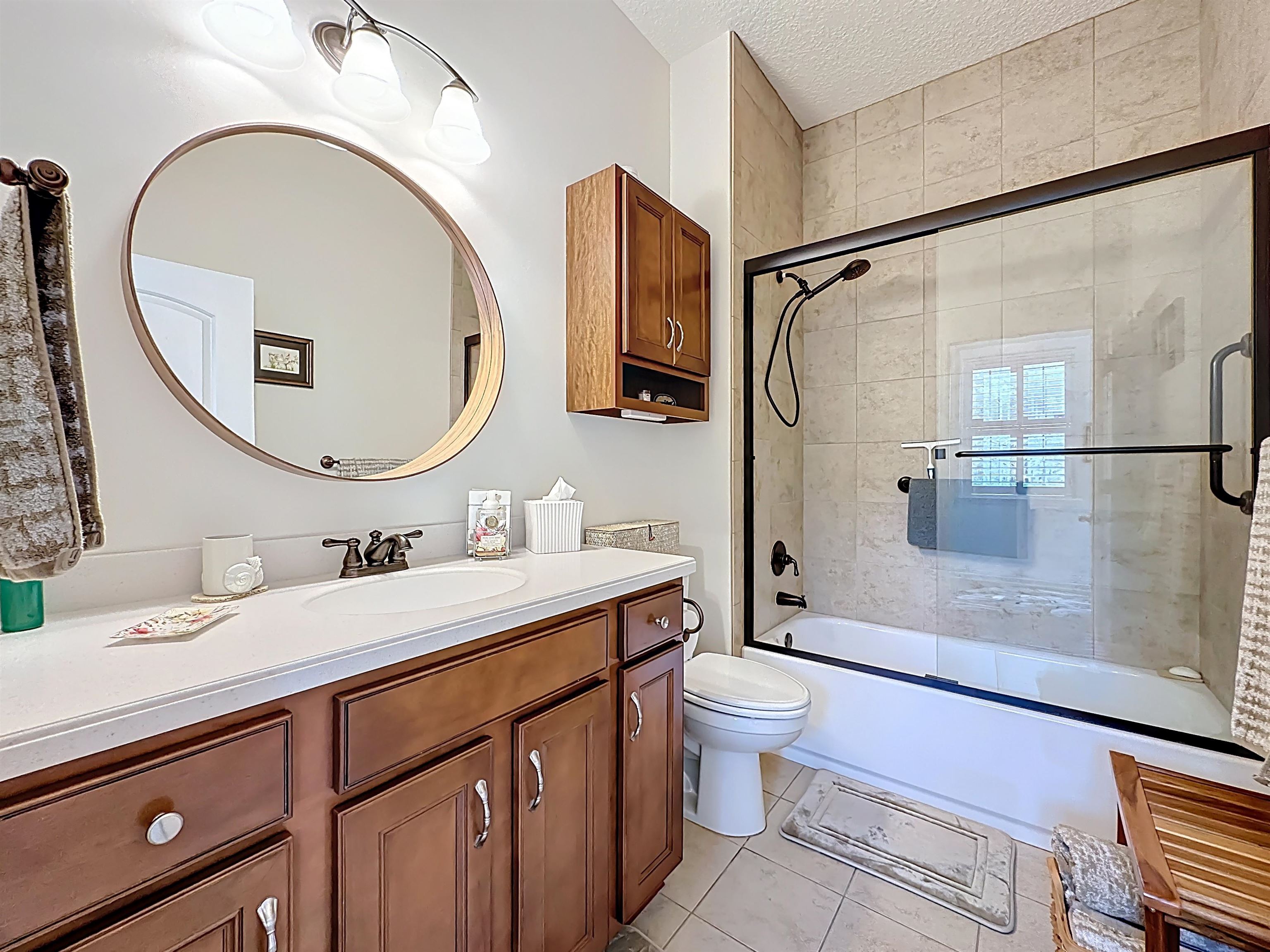 130 Grand Ravine Drive St. Augustine, FL 32086 - Photo 29 of 42 Full bathroom with vanity, bath / shower combo with glass door, a textured ceiling, and light tile patterned flooring