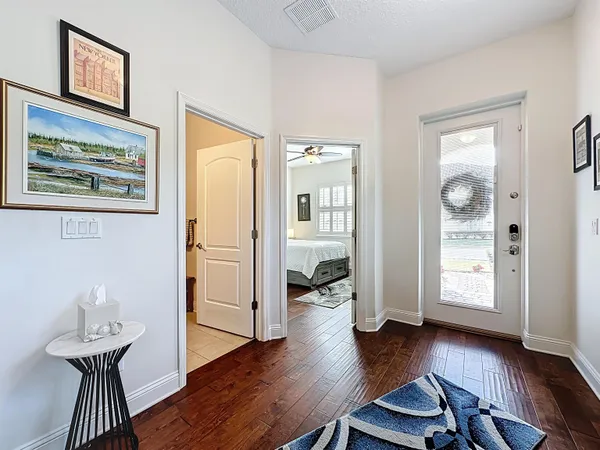 a view of a hallway with wooden floor windows and a kitchen