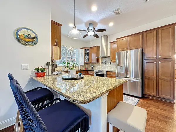 a large kitchen with stainless steel appliances granite countertop wooden floors granite counter tops and a window