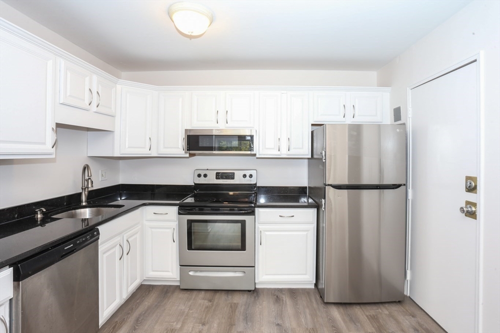 a kitchen with white cabinets and stainless steel appliances
