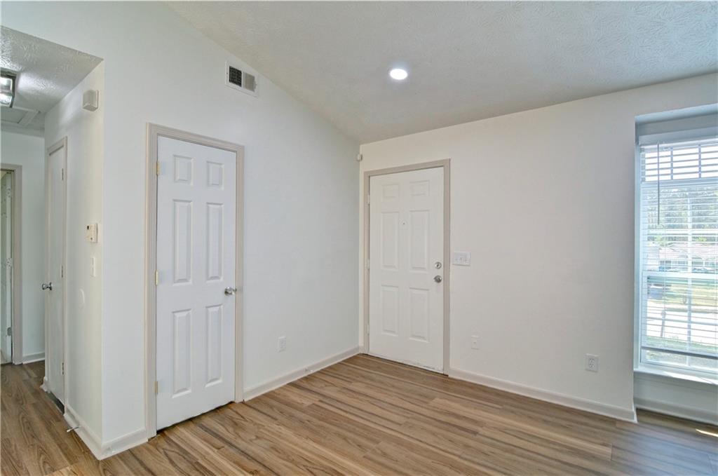 2665 Ivydale Court Southwest Atlanta, GA 30311 - Photo 12 of 45 a view of an empty room with wooden floor and a window