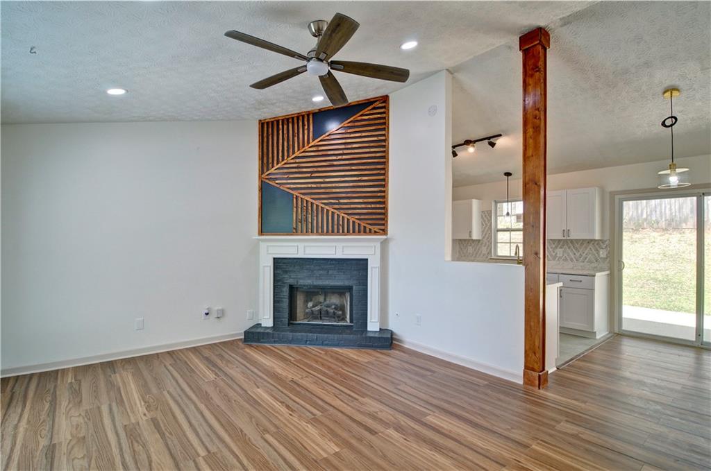 2665 Ivydale Court Southwest Atlanta, GA 30311 - Photo 7 of 45 an empty room with wooden floor a fireplace and windows