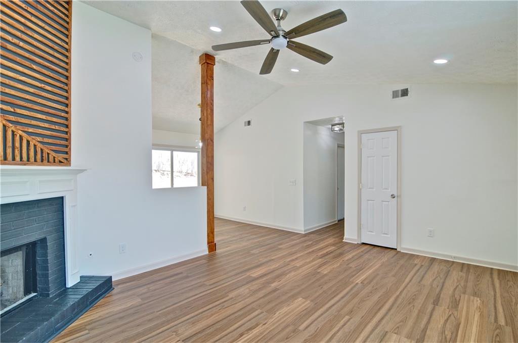 2665 Ivydale Court Southwest Atlanta, GA 30311 - Photo 8 of 45 an empty room with wooden floor a ceiling fan and windows