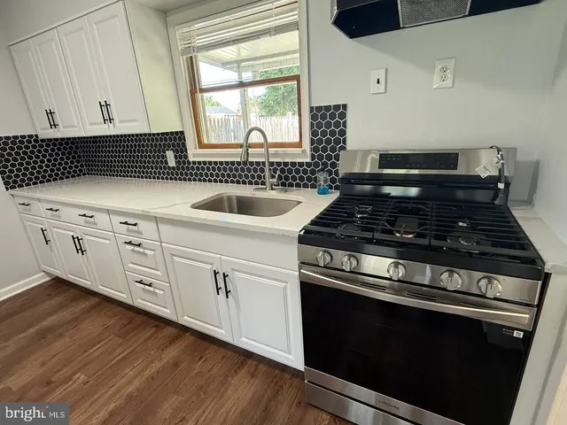 a kitchen with granite countertop white cabinets and black appliances