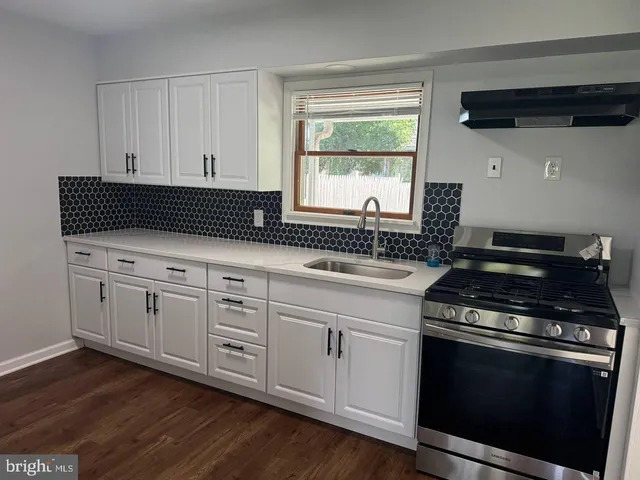 a kitchen with stainless steel appliances a stove a sink and a microwave
