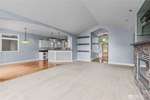 an empty room with fireplace and windows