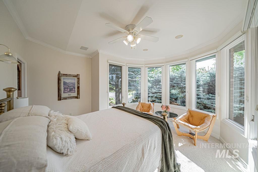 2700 North River Road St. Anthony, ID 83445 - Photo 25 of 50 Spacious Guest Bedroom with sitting area, walk-in closet and private ensuite bathroom has served various purposes over the years. It also features crown molding, custom windows with motorized blinds, and a ceiling fan.