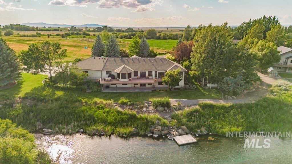 2700 North River Road St. Anthony, ID 83445 - Photo 3 of 50 View of the Back of the Main House with your own Private Dock. A small gravel road runs along the back of the property, providing convenient access to both the river and the guest house.