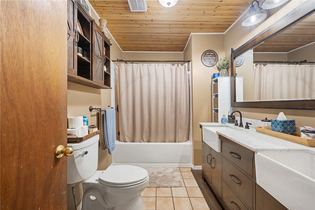 4450 Greenbriar Road Madisonville, TX 77864 - Photo 13 of 27 a bathroom with a sink a toilet a mirror and shower