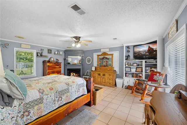 a bedroom with a bed a large window and dresser