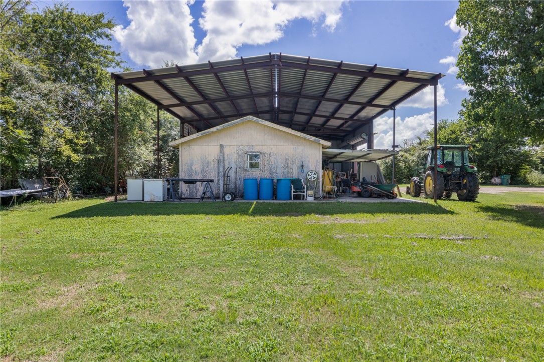 4450 Greenbriar Road Madisonville, TX 77864 - Photo 19 of 27 a view of a house with a backyard