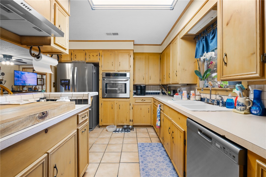 4450 Greenbriar Road Madisonville, TX 77864 - Photo 6 of 27 a kitchen with stainless steel appliances a sink and a refrigerator