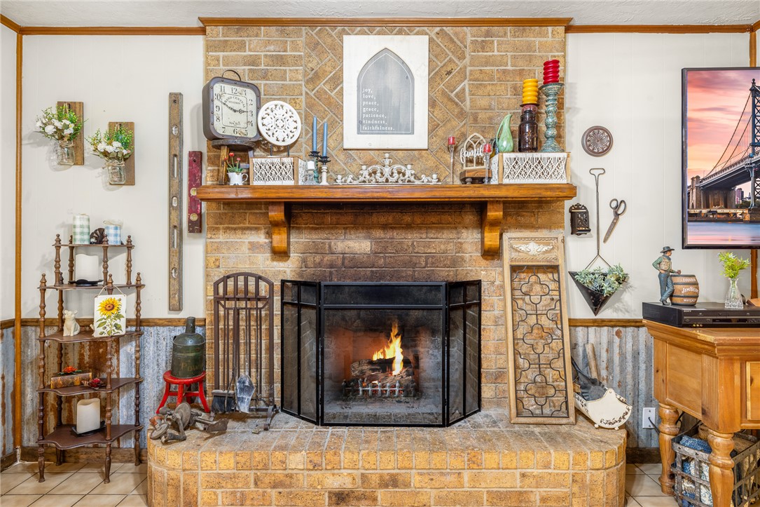 4450 Greenbriar Road Madisonville, TX 77864 - Photo 10 of 27 a living room with a fireplace a clock and a large window