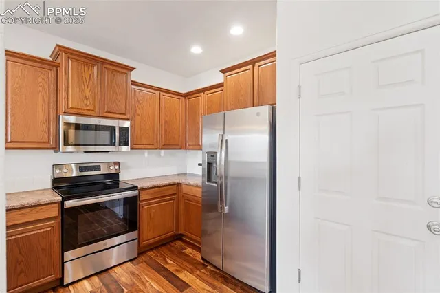 a kitchen with stainless steel appliances granite countertop a refrigerator and a stove top oven