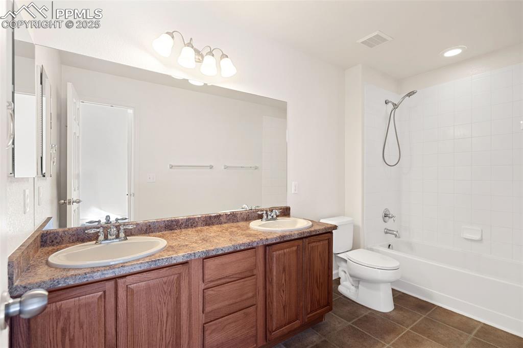 1243 Timber Run Heights Monument, CO 80132 - Photo 20 of 34 a bathroom with a granite countertop sink a toilet and shower