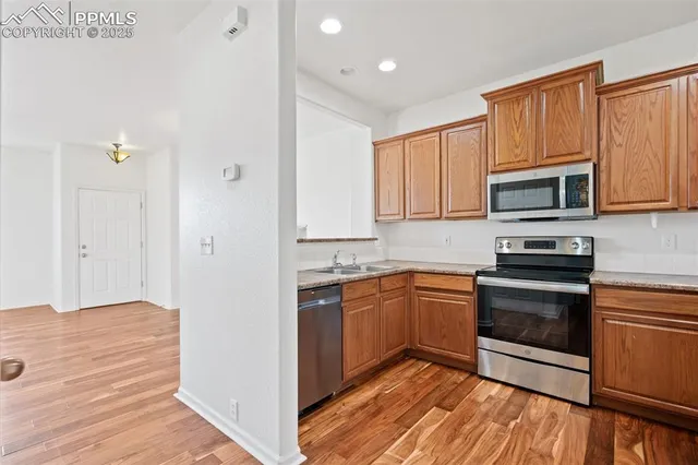 a kitchen with stainless steel appliances granite countertop a stove a sink and a microwave