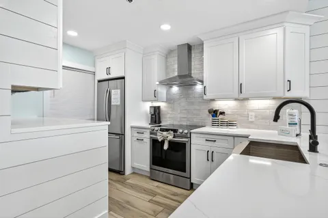 a kitchen with a stove and a wooden floor