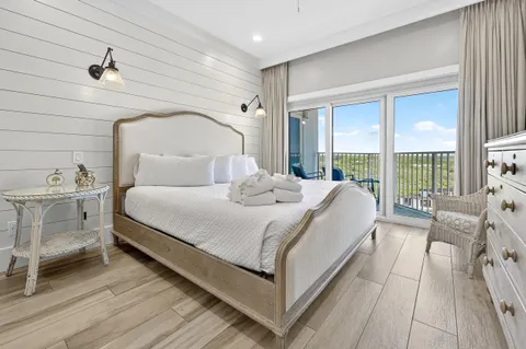 a bedroom with a bed and a flat tv screen on wall