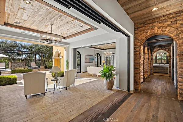 a living room with patio island furniture and a chandelier