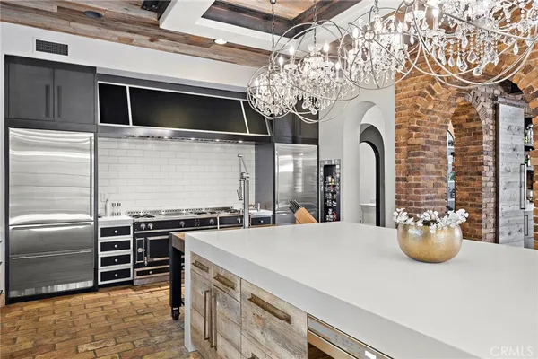 a spacious bedroom with a large bed a chandelier and closet