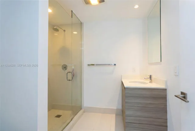 a bathroom with a shower sink vanity and mirror