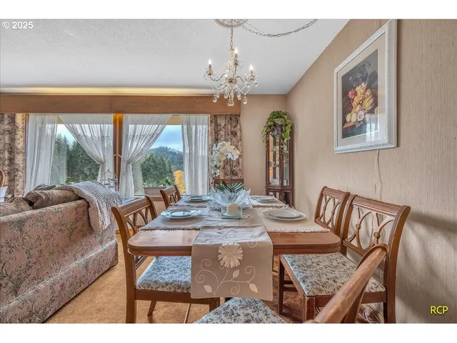 a dining room with furniture a large window and a chandelier
