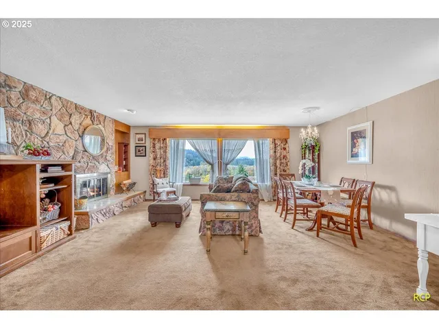 a living room with furniture a fireplace and a large window