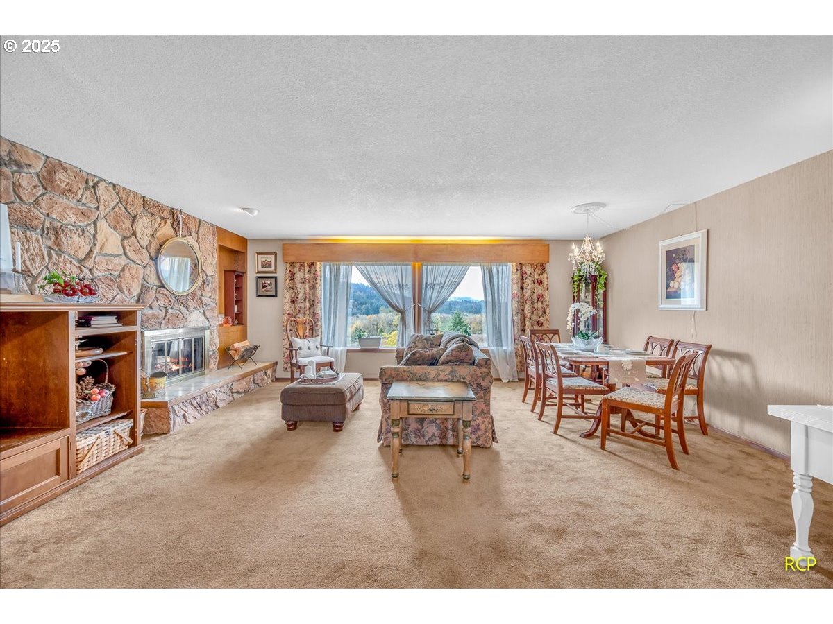 24312 Cardwell Hill Drive Philomath, OR 97370 - Photo 9 of 48 a living room with furniture a fireplace and a large window