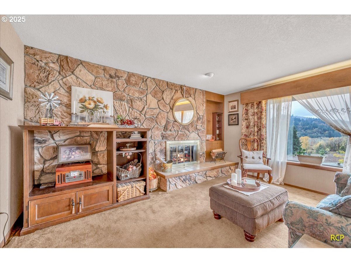 24312 Cardwell Hill Drive Philomath, OR 97370 - Photo 10 of 48 a living room with furniture a flat screen tv and a floor to ceiling window