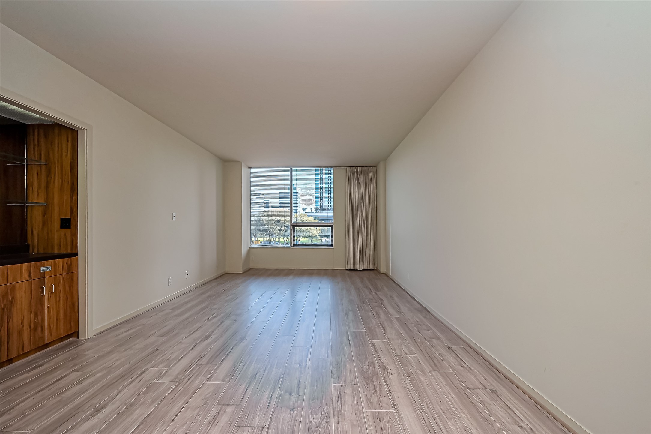 5100 San Felipe Street, Unit 34 Houston, TX 77056 - Photo 5 of 26 a view of an empty room with wooden floor and a window