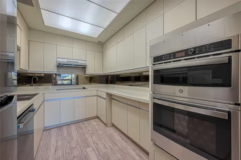 a kitchen with stainless steel appliances white cabinets and a stove top oven