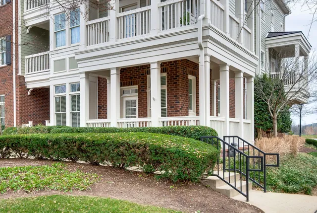 an open kitchen with wooden floor and stainless steel appliances