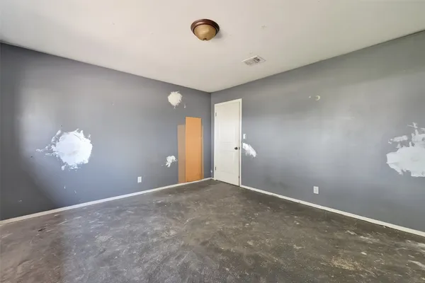 an empty room with windows and closet