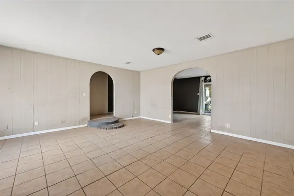 a view of an empty room with window and fire place