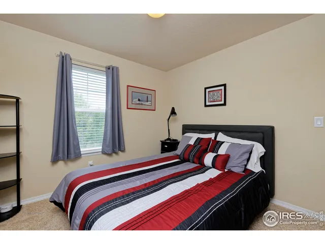 a bedroom with a bed and a painting on the wall