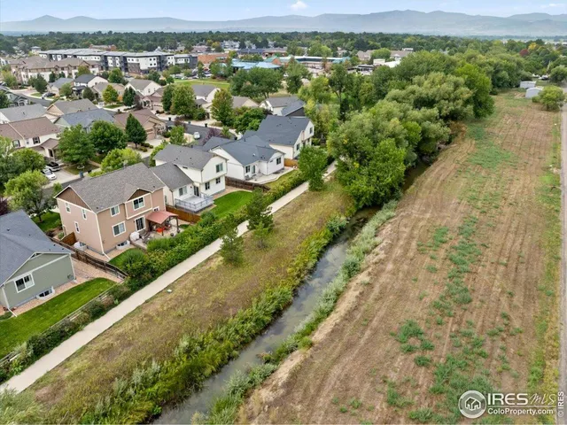 an aerial view of residential houses with outdoor space and river
