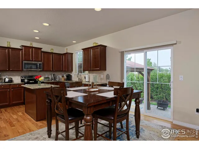 a kitchen with granite countertop a table chairs microwave and sink