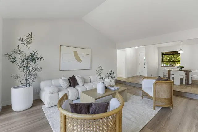 a living room with furniture a table and large windows