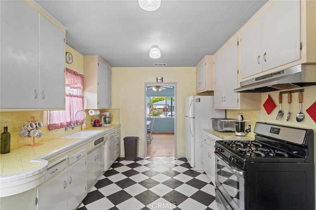7508 Brookmill Road Downey, CA 90241 - Photo 13 of 29 a kitchen with stainless steel appliances a stove a sink and a refrigerator