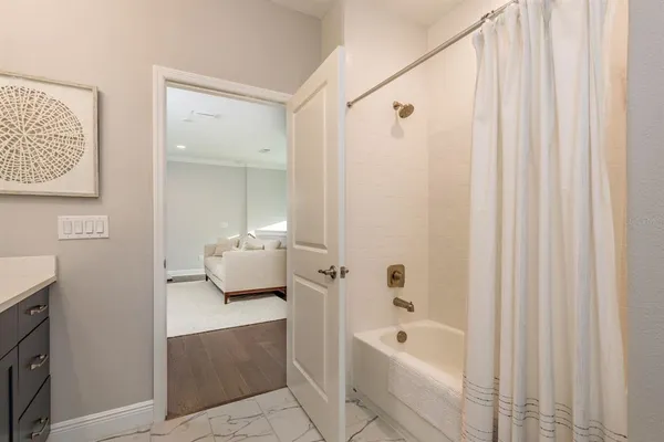 a bedroom with a bed a chandelier and dresser