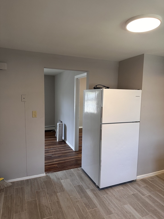 24 Concord Street, Unit 5 Ashland, MA 01721 - Photo 4 of 11 a view of a room with wooden floor and a refrigerator