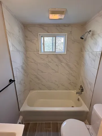 a bathroom with a toilet bathtub and shower