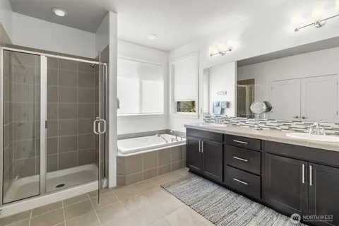 a bathroom with a tub sink shower and mirror