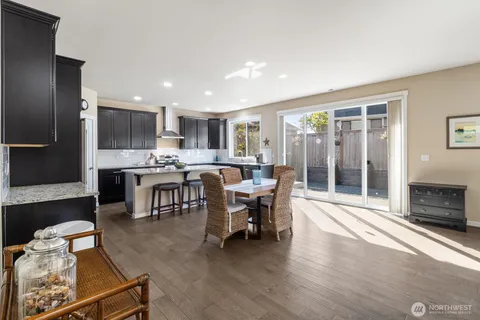 a living room with stainless steel appliances kitchen island granite countertop furniture and a fireplace