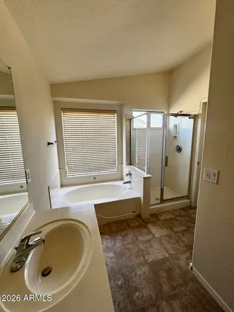 a bathroom with a tub a sink and a large window