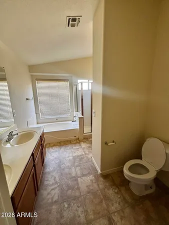 a bathroom with a granite countertop sink mirror vanity and toilet
