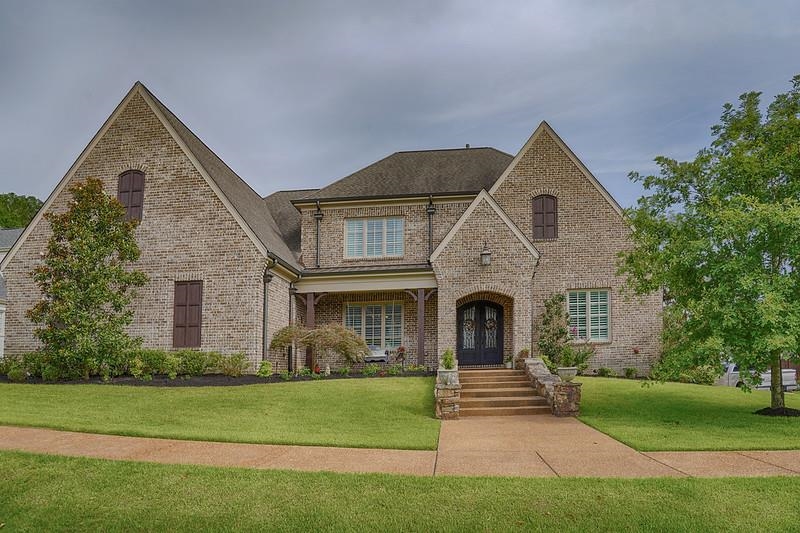 a front view of a house with a garden and yard